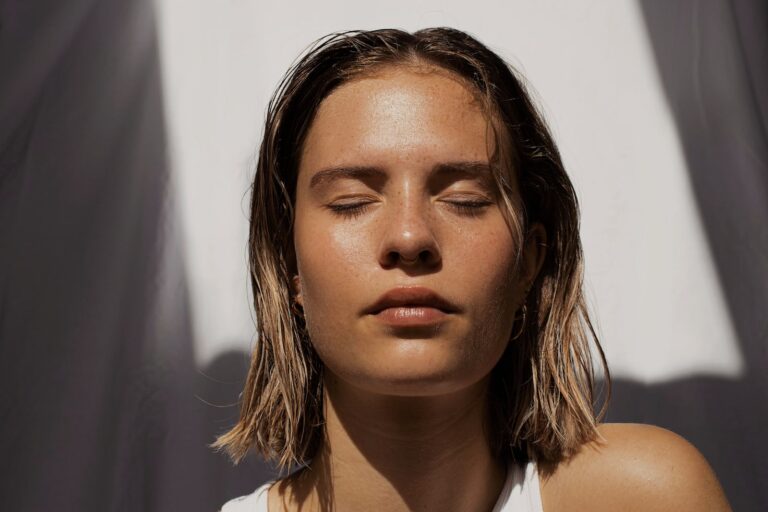 woman in white tank top with glowing skin